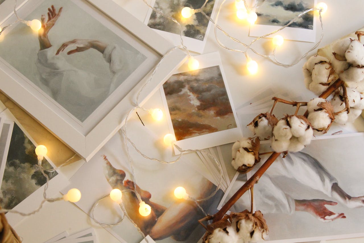 home-hero A collection of framed art pieces, cotton flowers, and string lights creating a cozy atmosphere.