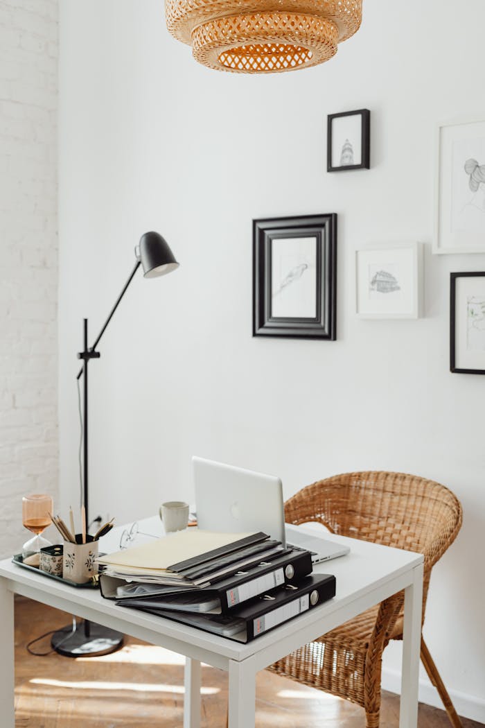 services-04 Elegant home office with wicker chair, white desk, and decor accents for a serene working space.